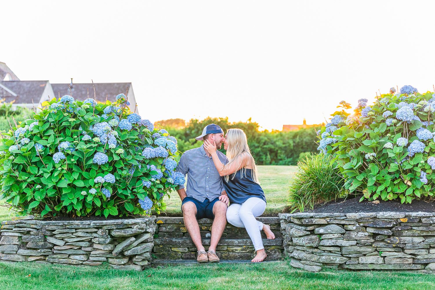 Devinn&Tyler engagement photo sitting between hydrangea bushes