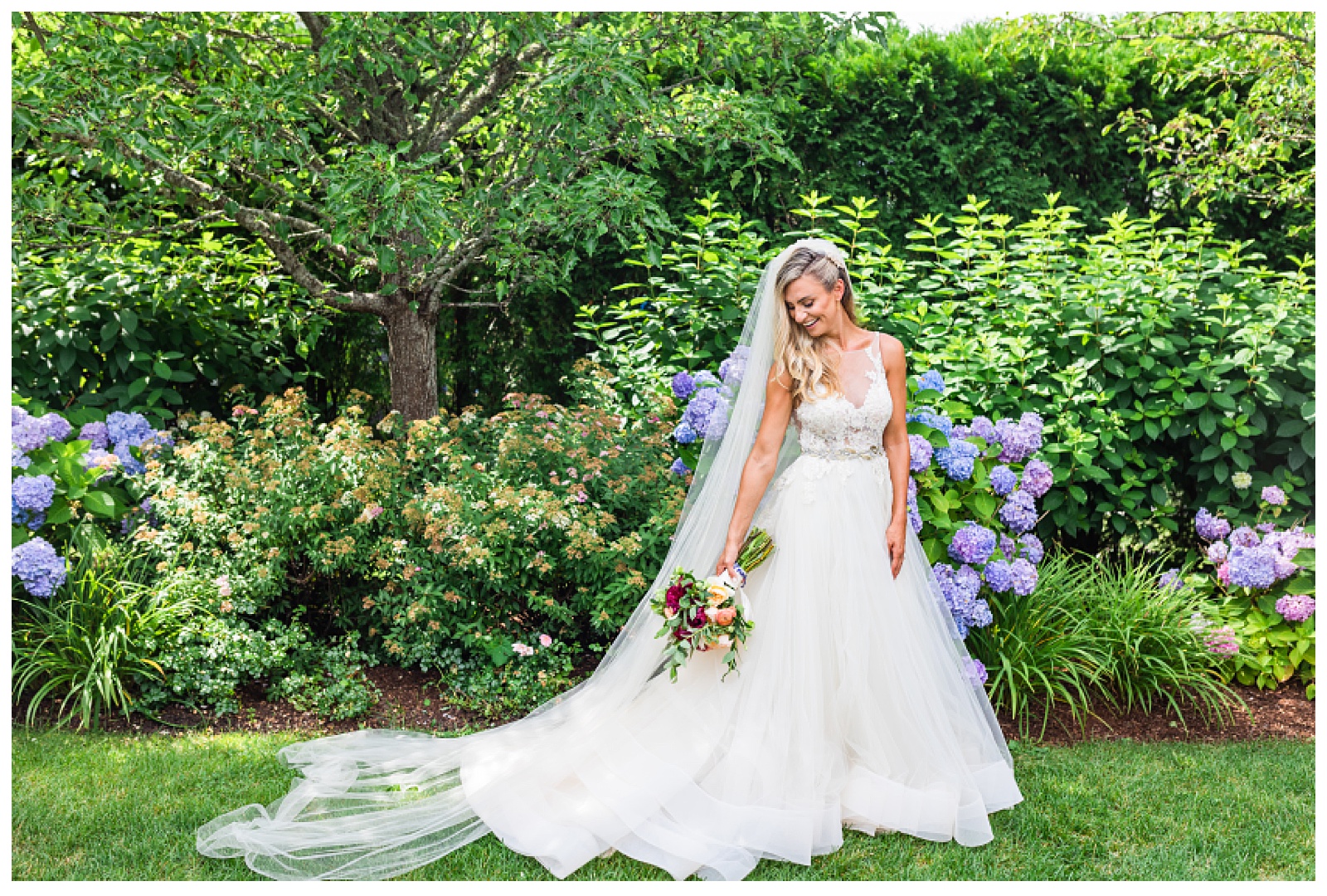 bride holding bouquet looking down at ground. full body shot