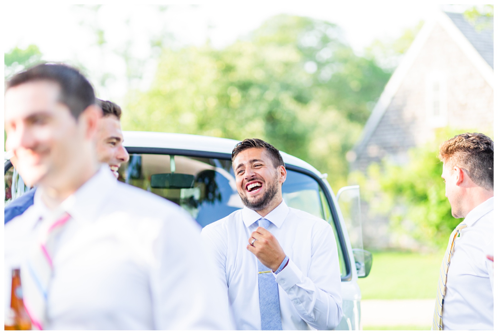 groom laughing while hanging with friends